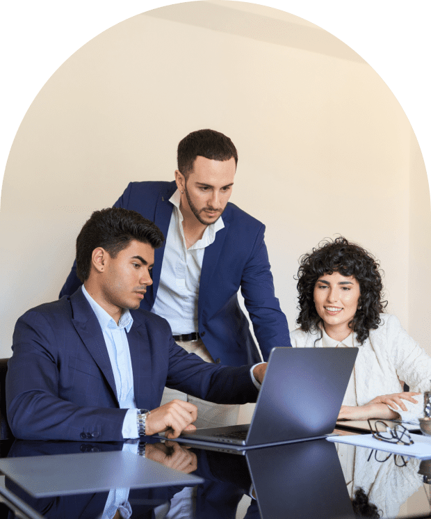 Three colleagues collaborating around a laptop.