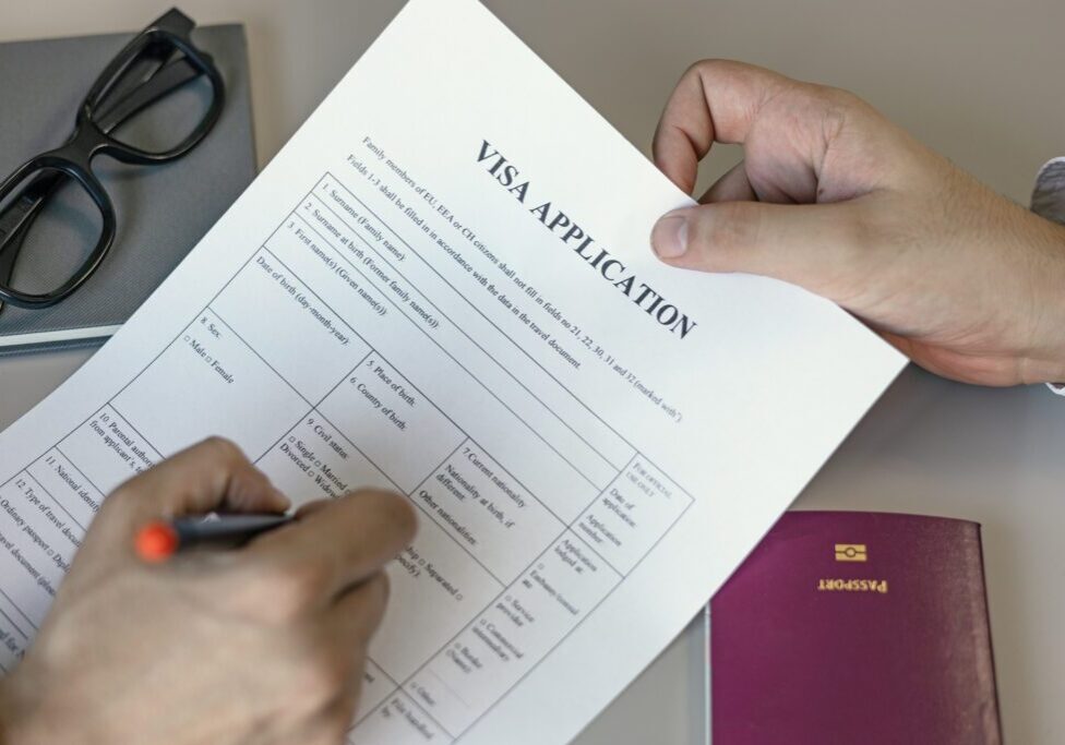 Person filling out a visa application form.